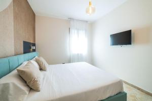 a bedroom with a bed with a blue headboard and a television at Taormina Sea View Apartment in Taormina +34 photos