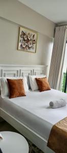 a bedroom with a large bed with white sheets and pillows at Modern Cozy Studio in Nairobi