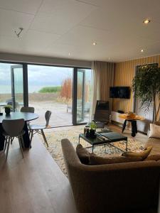 un soggiorno con un divano e un tavolo di Enkhuizer Strand BeachHouse Sinne Nr 514 a Enkhuizen