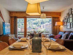ein Esszimmer mit einem Tisch und Weingläsern darauf in der Unterkunft Apartment Rossignol C4 by Interhome in Nendaz
