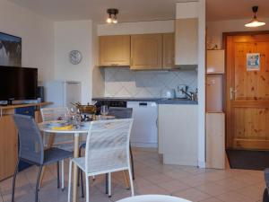 a kitchen with a table and chairs and a kitchen with white appliances at Apartment Grand Panorama A11 by Interhome in Nendaz +26 photos