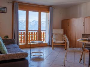a living room with a couch and a table at Apartment Grand Panorama A11 by Interhome in Nendaz
