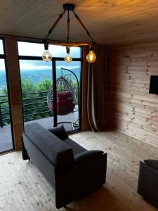 a living room with a couch and a swing at Kvirike Hills Cottages in Kobuleti