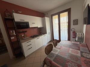 ロザピネタにあるApartment Solmare-16 by Interhomeの白いキャビネットとテーブルと椅子のあるキッチン