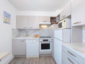 a white kitchen with white appliances and white cabinets at Apartment L'Océan by Interhome in Vaux-sur-Mer
