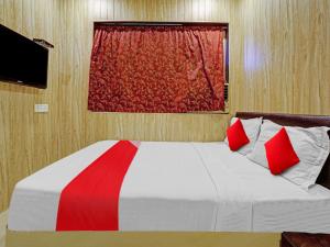 TurambheHotel Yatri Inn Vashi Navi Mumbai的卧室内的一张带两个红色枕头的床 更多17张照片