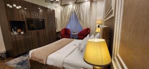 a hotel room with a large bed and a television at The Belmorris in Multan
