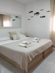 a white bedroom with a bed with towels on it at La Mediterránea in Moraira