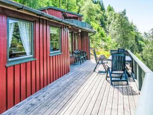un ponte di una casa rossa con delle sedie sopra di Holiday Home Neset by Interhome a Lyngdal