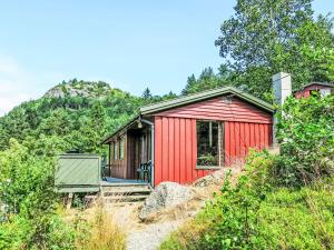 una casa rossa con una panchina davanti di Holiday Home Neset by Interhome a Lyngdal Altre 10 foto