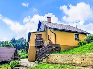 a yellow house on top of a green hill at Holiday Home Dolníky u Trutnova by Interhome in Oblanov