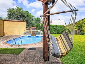 a swing in a yard with a swimming pool at Holiday Home Dolníky u Trutnova by Interhome in Oblanov
