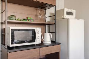 a microwave sitting on a counter next to a refrigerator at Macchiato SHONAN - 綺麗な古民家一棟貸切-海まで5分-無料駐車場-自転車2台-独立乾燥機-お子様大歓迎 Private Traditional House Near Kamakura Hakone, Family-Friendly Stay in Hiratsuka