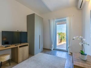 een woonkamer met een televisie en een glazen schuifdeur bij Holiday Home Da Lisa by Interhome in Fiorino