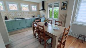 a kitchen with a table and chairs in a room at L'embellie in Mouzon