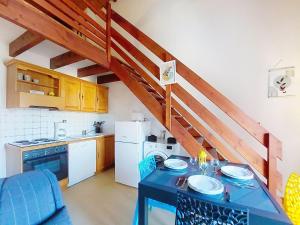 Una cocina con una mesa azul y una cocina con una escalera. en Apartment Moulin de la Brunette-6 by Interhome, en Saint-Palais-sur-Mer