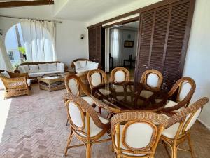 un soggiorno con tavolo e sedie in vimini di Dream Villa - Sea View, 4BR, Terrace & Garden a Fnidek