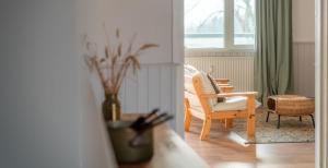 a living room with a chair and a table at Strandkoje - Landhaus in Neustadt in Holstein +3 photos