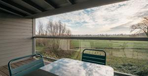 a screened porch with a table and a view of a field at Strandkoje - Landhaus in Neustadt in Holstein