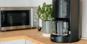 a coffee machine sitting on a counter next to a microwave at Strandkoje - Landhaus in Neustadt in Holstein