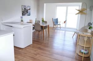 a kitchen and living room with a table and chairs at Strandkoje - Leuchtturm in Neustadt in Holstein