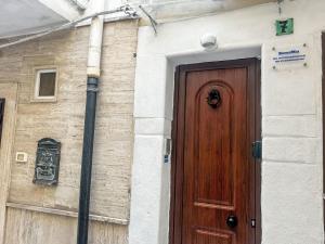 een houten deur aan de zijkant van een gebouw bij Holiday Home RomaMia by Interhome in Mola di Bari