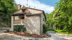 an old brick building in a park with trees at Urbino e Gola del Furlo, Idromassaggio Lux in Stazione delle Pole-Piobbico +10 photos