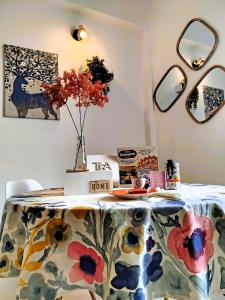 a table with a floral table cloth and a vase of flowers at Verona Bed and Relax Apartment in Verona