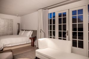 een witte slaapkamer met een bed en een raam bij Pillows Luxury Boutique Hotel Inter Scaldes in Kruiningen