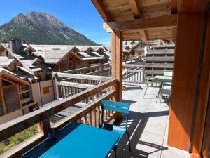 a balcony with tables and chairs and a mountain at Duplex de luxe 96m² - Terrasse - Ski au pied - 9 Pers. - FR-1-445-221 in Montgenèvre
