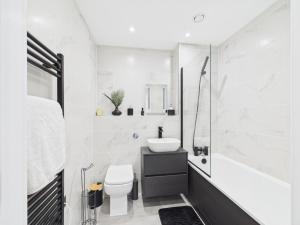 a white bathroom with a sink and a toilet at Stylish 2 Bedroom Flat | Sleeps 4 | in Brent Station
