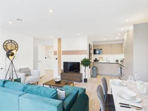 a living room with a blue couch and a table at Stylish 2 Bedroom Flat | Sleeps 4 | in Brent Station