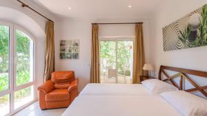 une chambre avec deux lits et une chaise et une fenêtre dans l'établissement Villa Grazalema 2 - Villa 39 Arcos de la Frontera by Ruralidays, à Arcos de la Frontera 27 autres photos