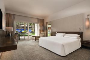 a bedroom with a white bed and a living room at Dusit Thani LakeView Cairo in Cairo