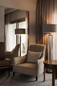a living room with a chair and a table at Dusit Thani LakeView Cairo in Cairo