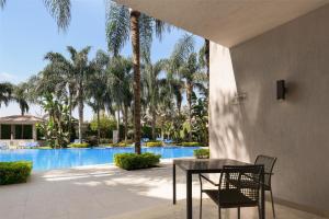 a patio with a table and chairs next to a pool at Dusit Thani LakeView Cairo in Cairo