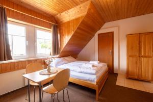 a bedroom with a bed and a table and chairs at Aberto Jizerky in Albrechtice v Jizerských horách