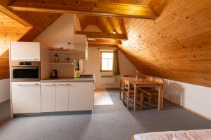 a kitchen with white cabinets and a wooden ceiling at Aberto Jizerky in Albrechtice v Jizerských horách +59 photos