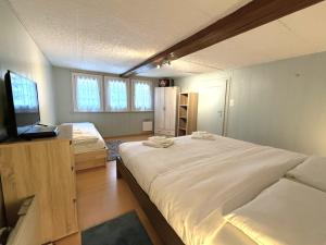 a bedroom with a large bed and a television at Chalet-Etage Mitten im Dorf in Leukerbad