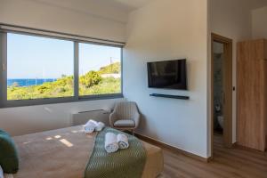 a room with a bed and a tv and a window at AK-Green Villa near Athens Airport in Vravrona