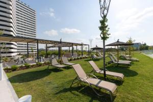 a group of lounge chairs and umbrellas on the grass at Be Casa Alcobendas in Alcobendas