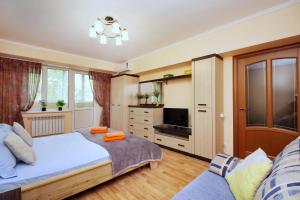 a bedroom with a large bed and a tv at Меркур возле Аэропорта in Almaty