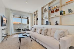 ein weißes Wohnzimmer mit einer Couch und einem Tisch in der Unterkunft Penthouse La Noria in Mijas Costa