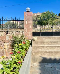 a stone wall with a gate and a bunch of flowers at PETRINO Hotel in Mythimna +25 photos