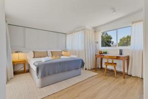 ein Schlafzimmer mit Bett, Schreibtisch und Fenster in der Unterkunft Penthouse La Noria in Mijas Costa + 43 Fotos