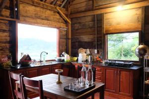 a kitchen with a wooden table and a window at Plinh Homestay in Kon Plong
