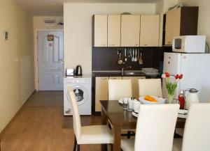 a kitchen with a dining table and a white refrigerator at Two bedroom Apartment in Fort Noks Panorama beach in Elenite +9 photos