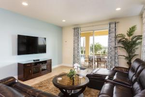 a living room with a leather couch and a television at Villa EC036 in Orlando