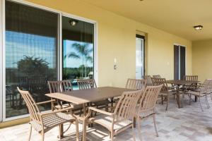 a dining room with tables and chairs and a large window at Villa EC036 in Orlando