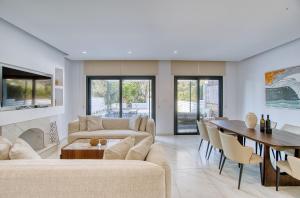 a living room with two couches and a dining room at River Pearl Villa in Tala